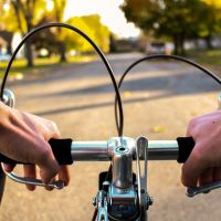 first-person view over handlebars riding a bike on a suburban street